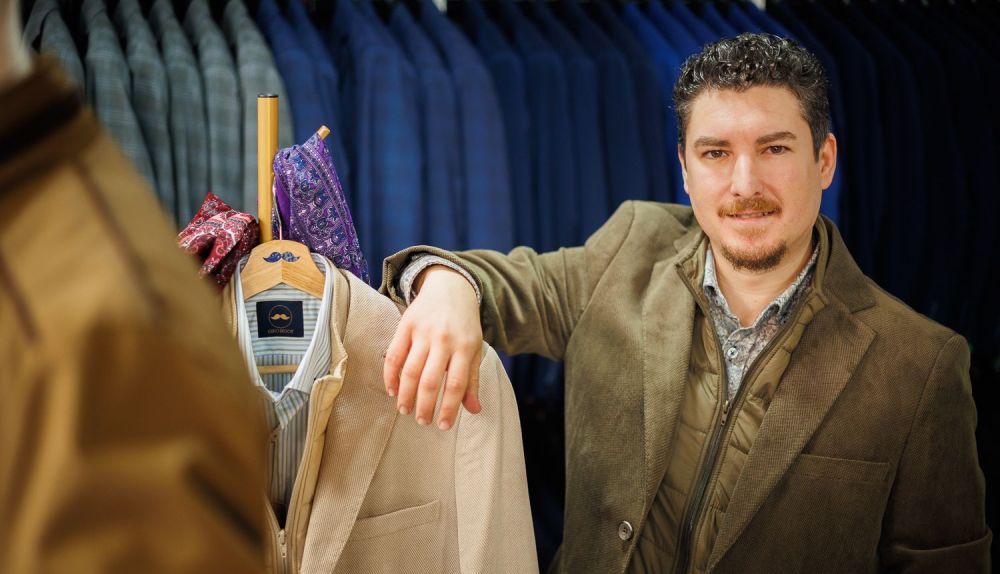 El propietario de Kiko Bigot posando junto a una chaqueta de la colección que tiene a la venta. 