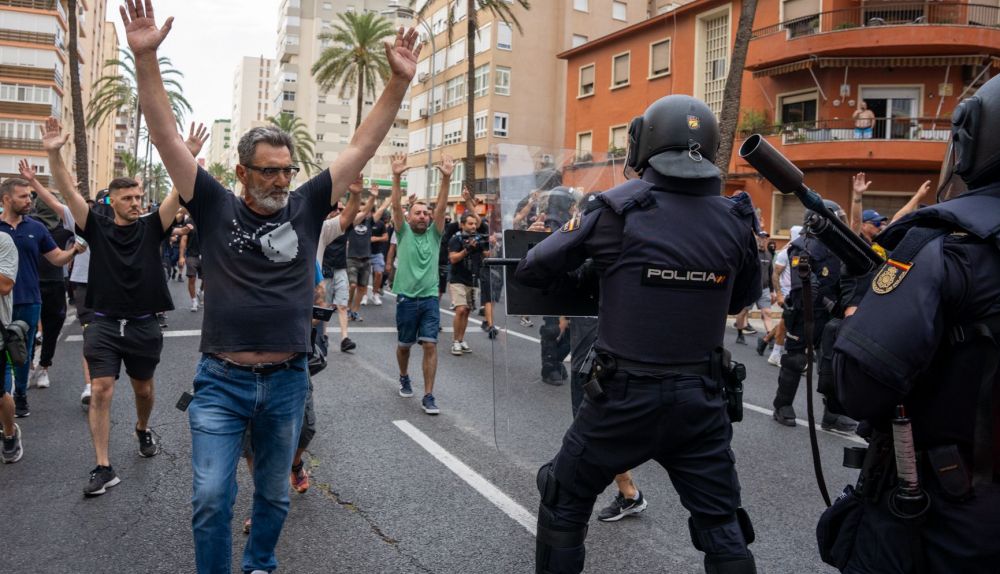 Manifestante avanza por la avenida principal al paso junto al cordón policial durante la movilización del sector del metal