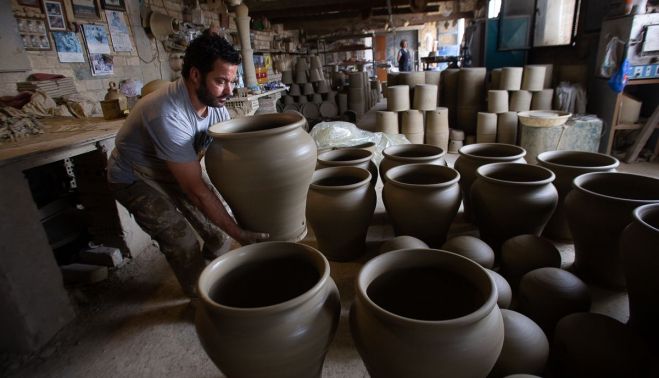 El alfarero Juan Sebastián López, en su taller, colocando una maceta de grandes dimensiones. Autor: Juan Carlos Toro